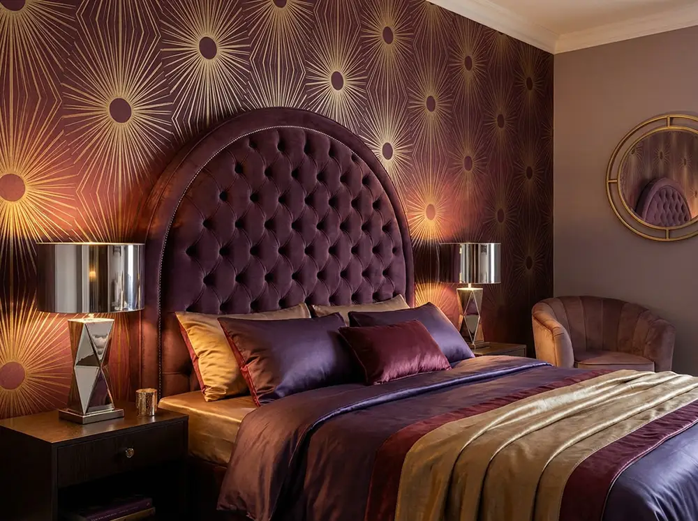 chambre neo art deco tete lit velours prune Chambre neo art déco avec tête de lit en arc velours prune, papier peint radiant bordeaux et or, lampes chrome poli